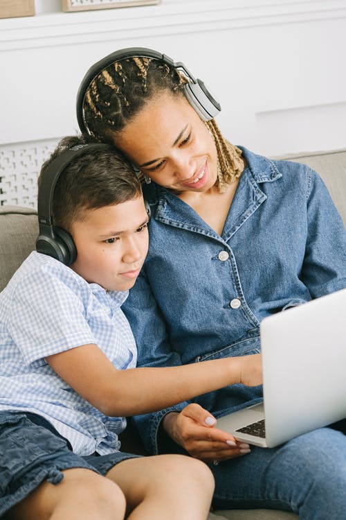 a boy wearing headphones and using a laptop